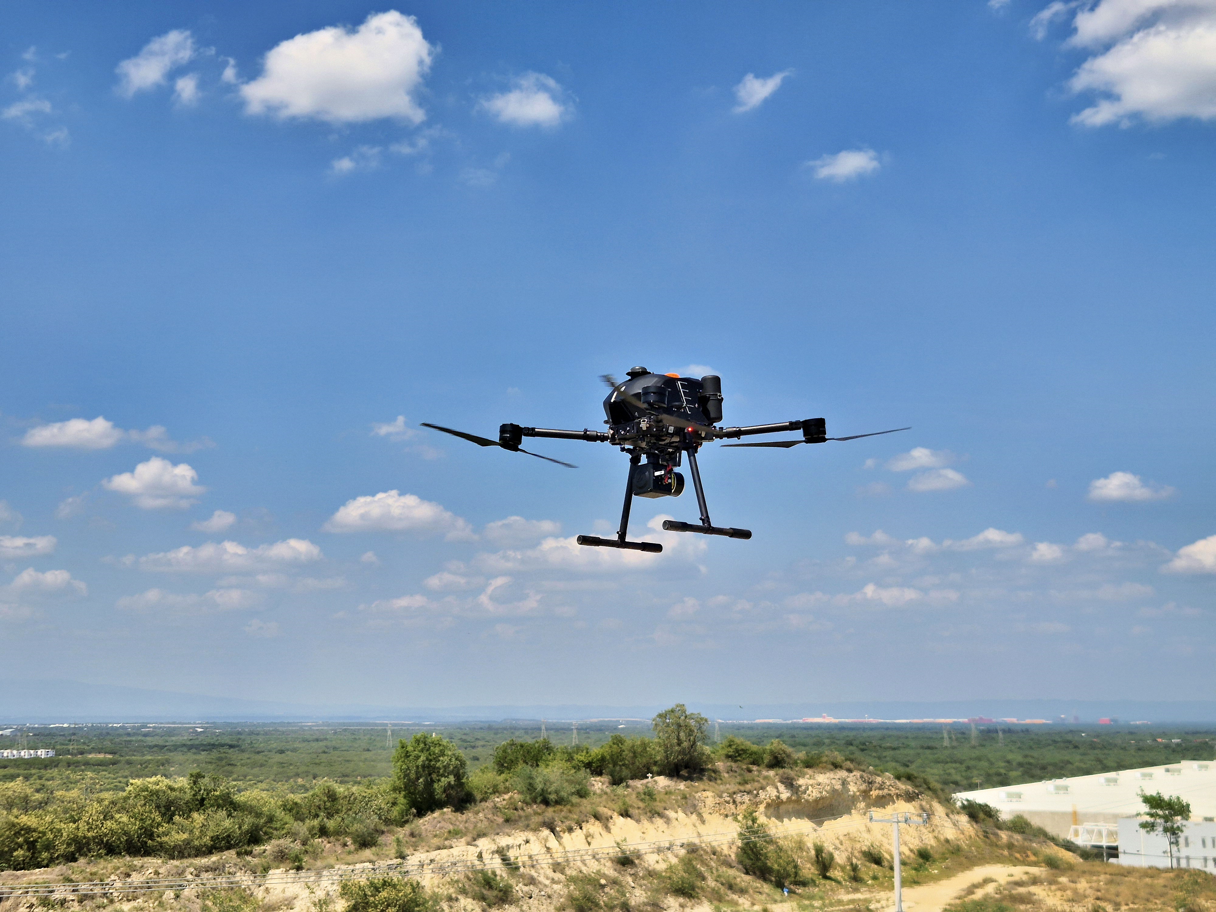 Professional mapping drone in flight over terrain